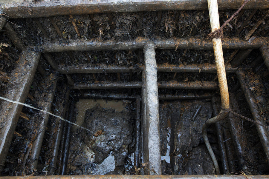 Looking down into a shallow pit mine, cut into the floor of a rice field.
